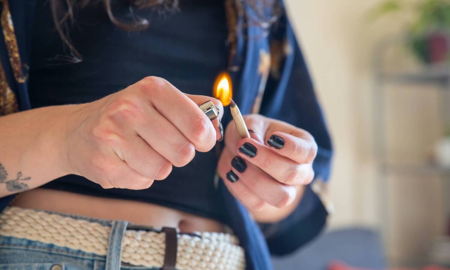 Woman lighting a marijuana joint